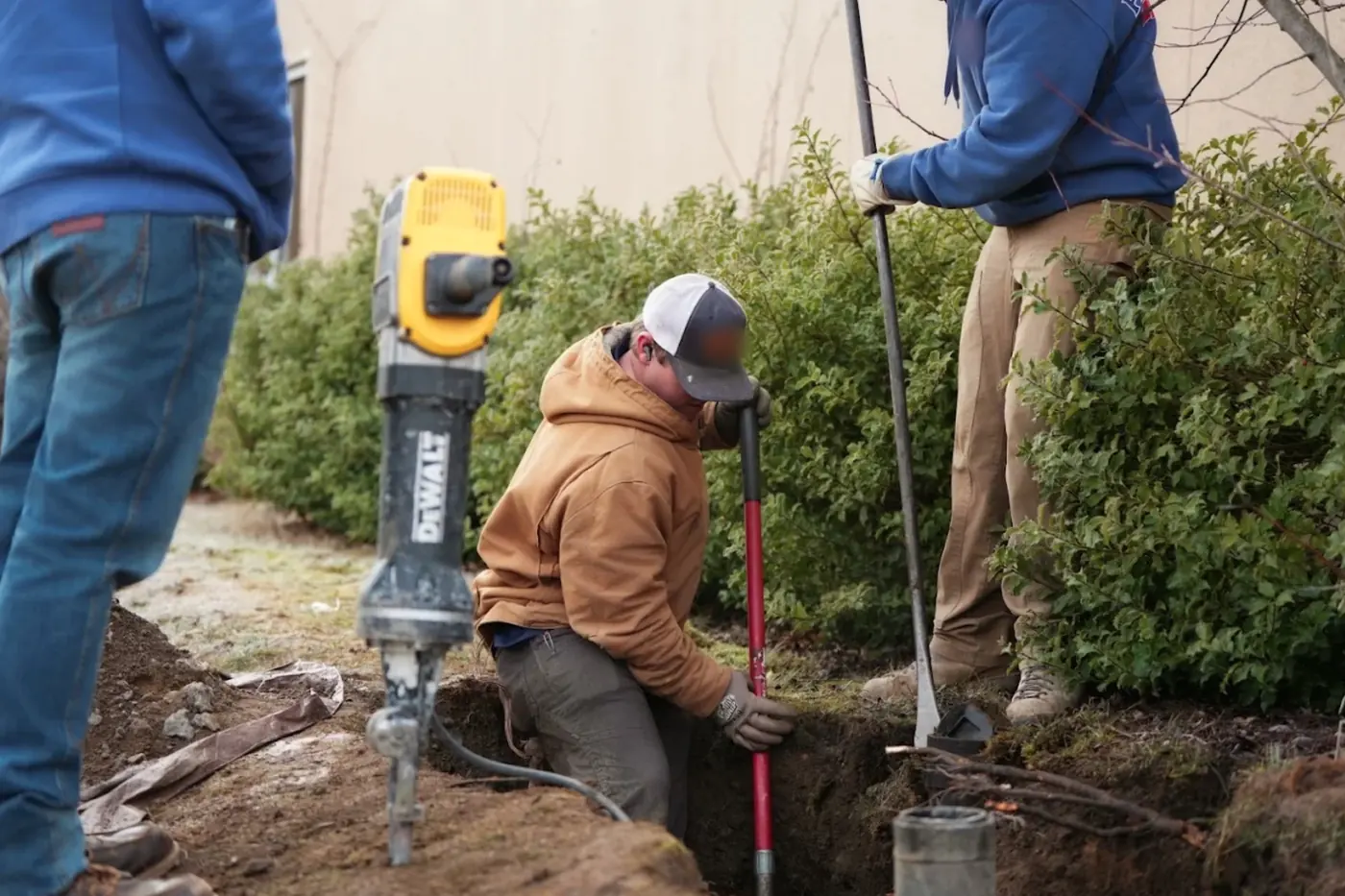Plumbing crew digging a trench to reach a sewer line